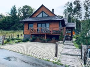 a wooden house with a porch and a driveway at Chata Lipa in Smrečany