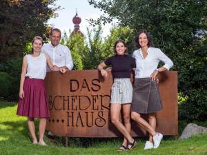a group of people standing in front of a sign at Appartements Schedererhaus in Going am Wilden Kaiser