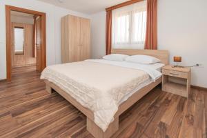 a bedroom with a large bed and a wooden floor at Ethno Village St George in Cetinje