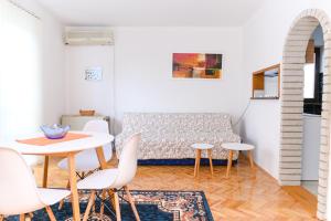 a living room with a couch and a table and chairs at Apartman Greta in Soko Banja