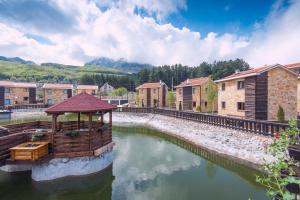 a river with a gazebo in the middle at Ethno Village St George in Cetinje