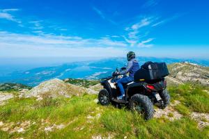 a person riding a atv on top of a mountain at Ethno Village St George in Cetinje