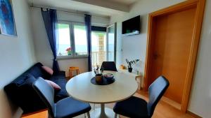 a living room with a table and a couch at Apartments Blueness in Prigradica