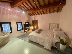 サン・カシャーノ・イン・ヴァル・ディ・ペーザにあるFienile toscano con piscina privataのベッドルーム(白いベッド1台、ソファ付)