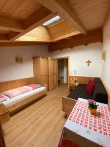 a room with two beds and a cross on the wall at Peterlungerhof in Siusi