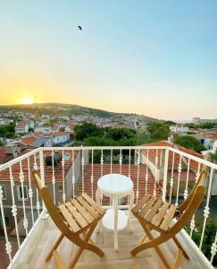a balcony with two chairs and a table at TaşAda Hotel - Special Class in Bozcaada