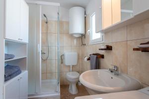 a bathroom with a toilet and a sink and a shower at Apartment Lazić Pag by Pag tours in Pag +31 photos