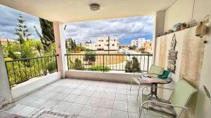 a balcony with a table and chairs and a view of a city at Anthea Gardens - Cosy Condo in Paphos