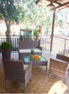 a patio with chairs and a table with a bowl of fruit at playa home in Catania