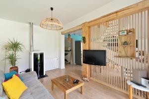 a living room with a couch and a tv at Séjour et Forme Route de Biarritz in Arbonne
