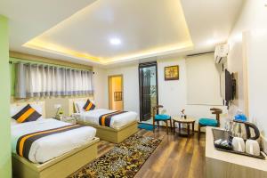 a hotel room with two beds and a television at Hotel Travel INN in Kathmandu