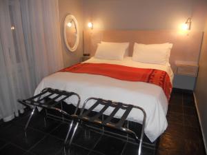 a bedroom with a large bed with a red blanket at Rose Lodge in Cape Town