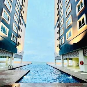 two tall buildings with water between them at New Seaview Families Suite - Breezy Blue in Kuala Terengganu