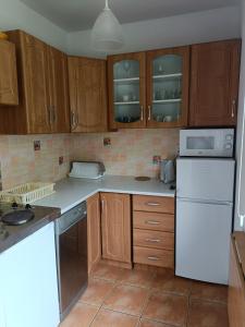 a kitchen with wooden cabinets and a white refrigerator at Dar Lasu in Szczytno