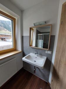 La salle de bains est pourvue d'un lavabo et d'un miroir. dans l'établissement Schmiederlerhof, à Neustift im Stubaital