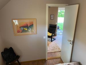 une porte ouverte menant à une chambre avec une chaise dans l'établissement Lilla Sandslätt, à Åhus