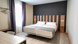 ein Schlafzimmer mit einem großen weißen Bett und einem Tisch in der Unterkunft Smart Hotel La Sagra in Yuncos
