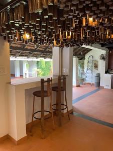 a kitchen with a bar with stools under a chandelier at Kayyalas Courtyard in Trichūr