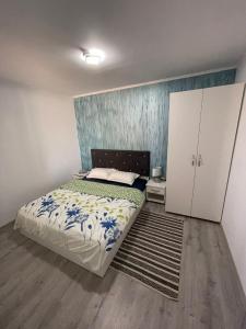 a bedroom with a bed with blue flowers on it at Gigios Sport&Relax in Băileşti