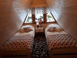 two beds in a small room with two windows at Górska Pasja Istebna in Istebna