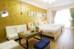 - une chambre avec un lit, un canapé et une table dans l'établissement Nippombashi Art Hotel 605, à Osaka