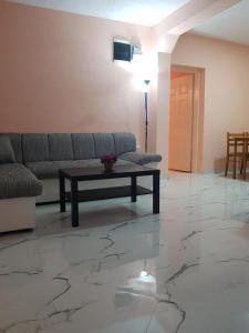 a living room with a couch and a table on a marble floor at Apartments Bulatović in Bar