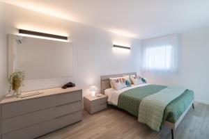 a bedroom with a bed and a dresser and a window at Zero5.Zero5 in Lignano Sabbiadoro