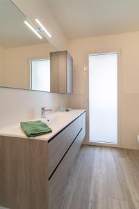 a bathroom with a sink and a large mirror at Zero5.Zero5 in Lignano Sabbiadoro
