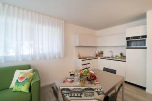 a small kitchen with a table and a green chair at Zero5.Zero5 in Lignano Sabbiadoro