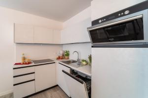 a white kitchen with a sink and a microwave at Zero5.Zero5 in Lignano Sabbiadoro