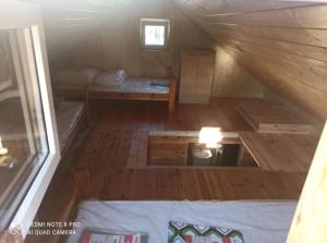 una camera mansardata con un letto in una cabina di legno di Domki letniskowe a Jedlinsk