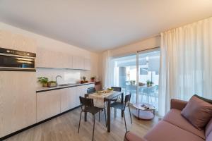 a kitchen and a living room with a table and chairs at Zero5.Zero5 in Lignano Sabbiadoro