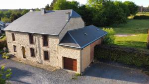 a small brick house with a black roof at L'Antre Parenthèse de Sainte-Cécile in Florenville