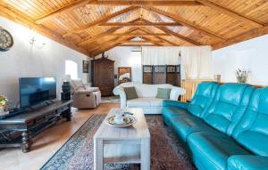 a living room with a blue couch and a tv at Villa Lenoir in Vrsar
