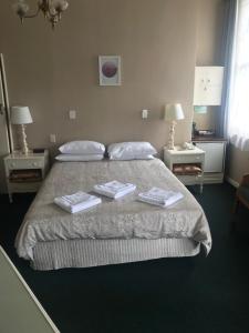 a bedroom with a bed with two towels on it at Grand Hotel - Whangarei in Whangarei