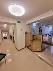 a woman standing at a counter in a building at Vila Central in Constanţa