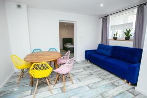a living room with a blue couch and a table and chairs at Domek z ogródkiem - sauna dla gości in Chęciny
