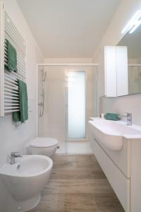a white bathroom with two sinks and a shower at Zero5.Zero5 in Lignano Sabbiadoro