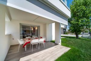 a patio with a table and chairs on a deck at Zero5.Zero5 in Lignano Sabbiadoro