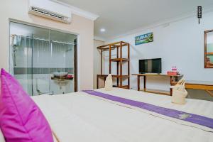 1 dormitorio con 1 cama blanca grande con almohadas rosas en Neakru Guesthouse and Restaurant en Kampot