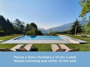 a pool with lounge chairs and a view of mountains at Rota Apartments - Cà Guaccio in Rota d'Imagna