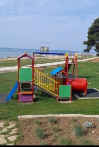 a playground with a slide in a park at Mobilna kuća T&D in Privlaka