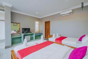 Neakru Guesthouse and Restaurant في كامبوت: سريرين في غرفة وردية وبيضاء