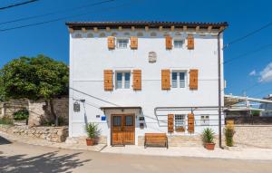 a white building with wooden shuttered windows at Villa Lenoir in Vrsar