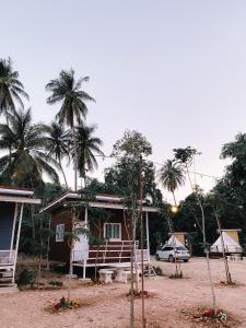 ein Haus mit Palmen davor in der Unterkunft NP โฮมสเตย์ นอนเต็นท์ติดแอร์ in Ban Kaeng Manao