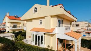 a white house with a red roof at Beach house 30 in Ialysos