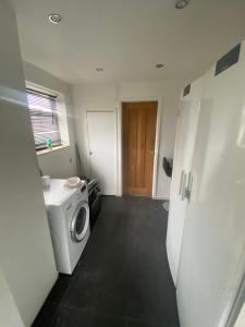a laundry room with a washing machine in it at Theldon in Luton
