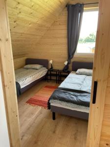 a room with two beds in a log cabin at Domki Rózin in Zwierzyniec