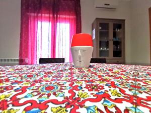 a table with a red hat on top of it at Scala dei Turchi Apartment in Realmonte