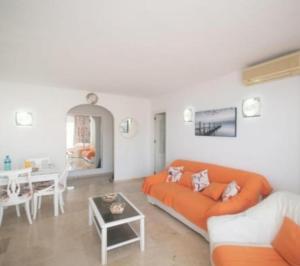 een woonkamer met een oranje bank en een tafel bij La duquesa in Fuengirola